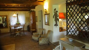A cozy living room with a dining area, wooden furniture, and a decorative partition.