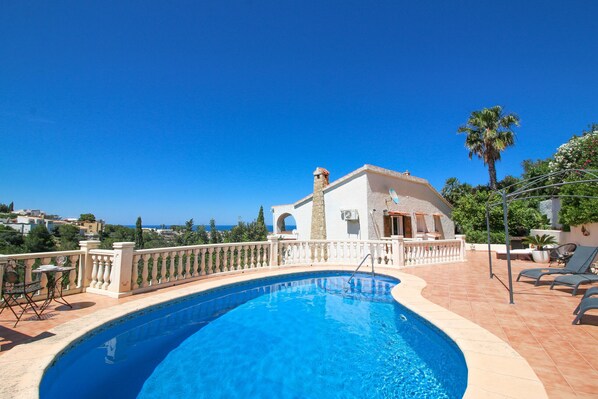 A swimming pool with a white balustrade, a stone pillar, and a view of the sea. - Villa with panoramic views and swimming pool Marquesa JM 4 people (Denia)