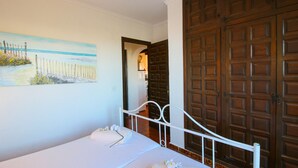 Una camera da letto con un letto, un quadro e una porta in legno.