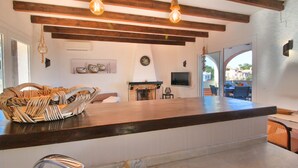 Una cucina con un piano di lavoro in legno, un camino e un'area pranzo con tavolo e sedie.