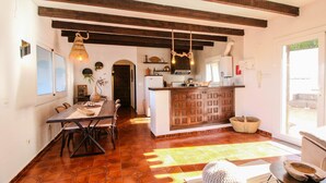 Una cucina con un'isola in legno, un tavolo da pranzo con sedie e un lampadario.