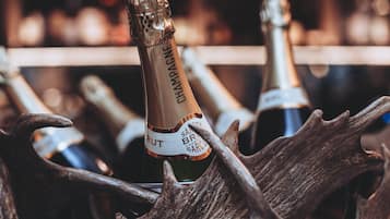 A bottle of champagne in a wooden holder with antlers.