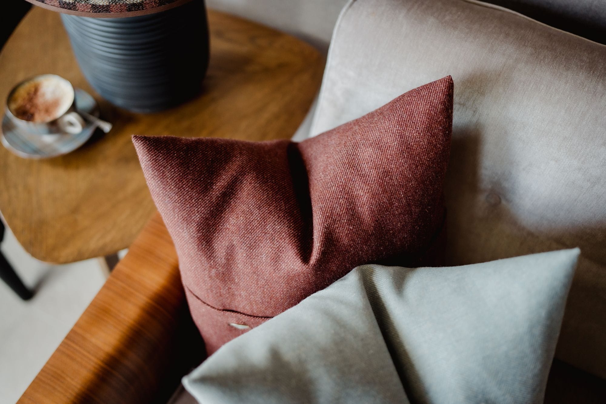 Un sofá con una almohada roja y una almohada gris.