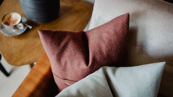 Un sofá con una almohada roja y una almohada gris.