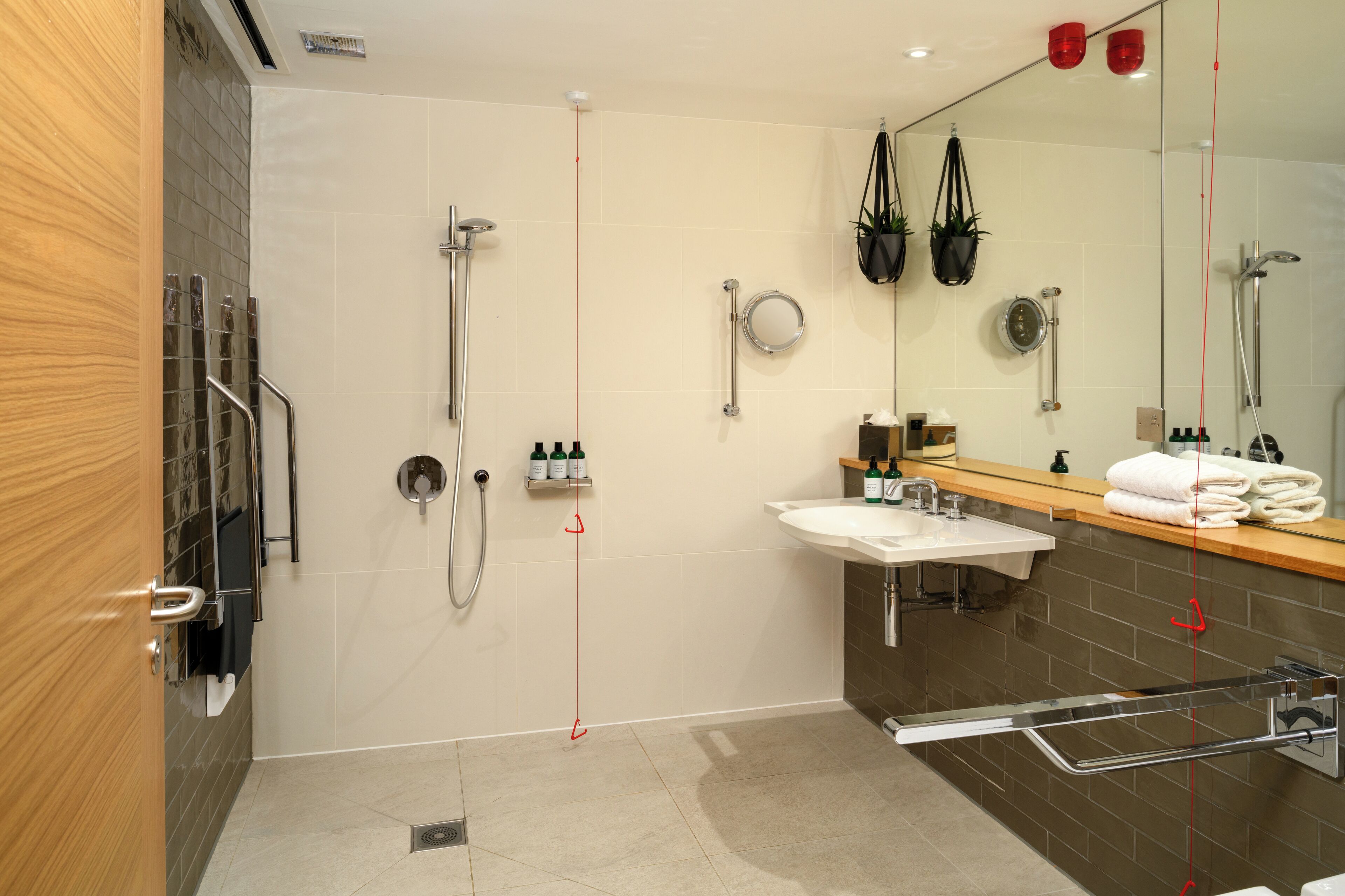 A modern bathroom with a shower, sink, and mirror.