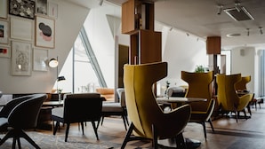 A modern interior with yellow and black chairs, wooden tables, and a patterned rug. - Market Street Hotel (Edinburgh)