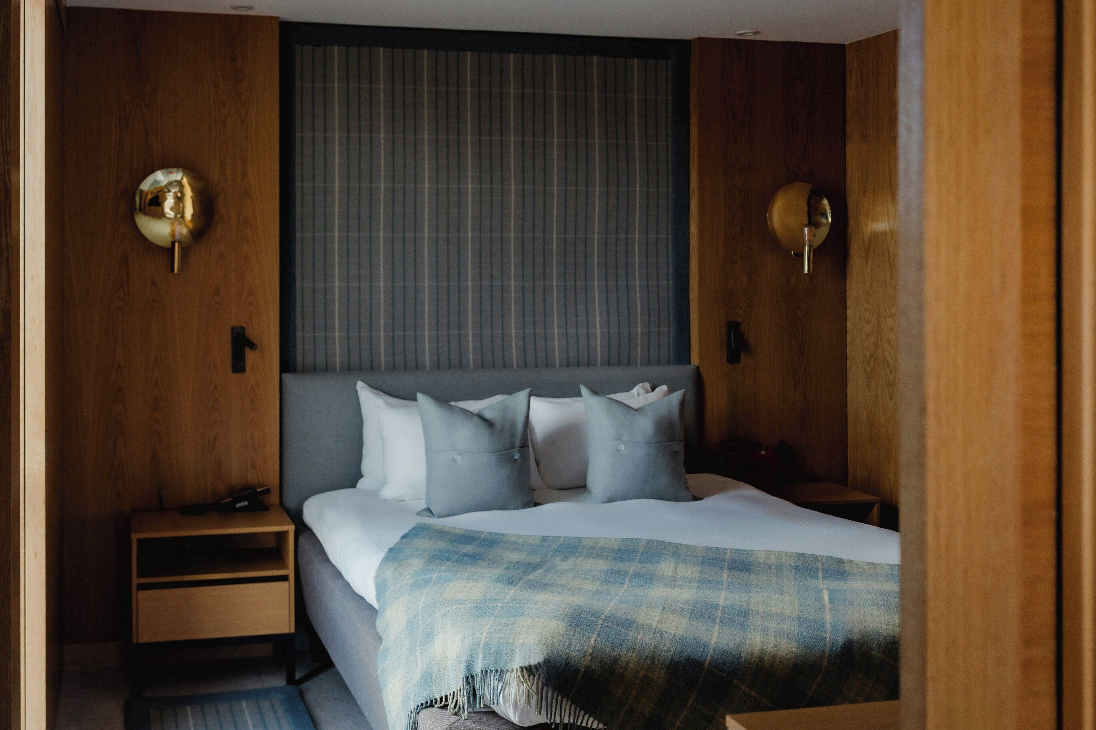 A neatly arranged bedroom with a bed, bedside tables, and a headboard.