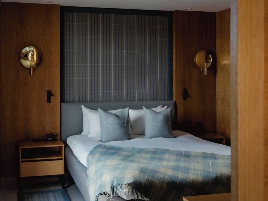 Une chambre à coucher bien rangée, avec un lit, des tables de chevet et une tête de lit.