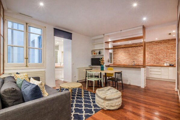 A modern apartment with a dining area, kitchen, and living room.