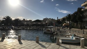 A marina with boats docked, a clear sky, and buildings in the background. - Bella Apartment for rent near to the beach Sarandë , Albania  (Saranda)