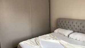 A bedroom with a bed, a headboard, and a wardrobe. - Bella Apartment for rent near to the beach Sarandë , Albania  (Saranda)