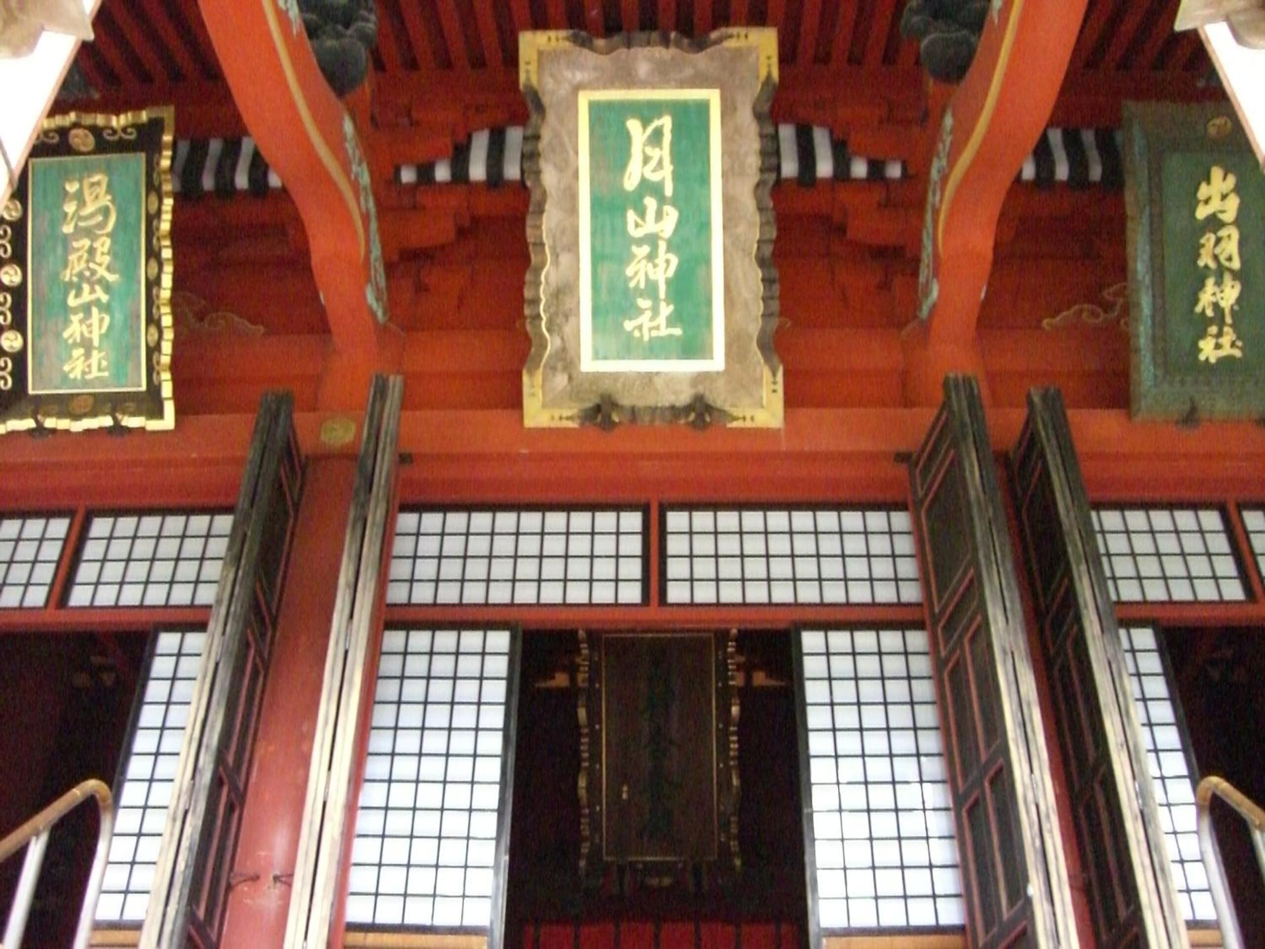 Ein traditioneller japanischer Innenraum mit Tatami-Bodenbelag, Schiebetüren und dekorativen Bannern mit chinesischen Schriftzeichen.