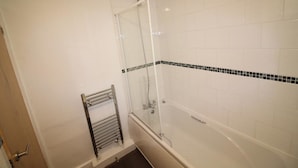 A bathroom with a glass shower enclosure, a bathtub, and a towel rack.
