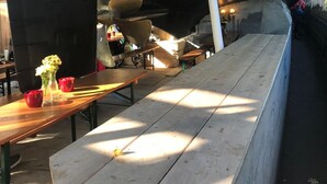 An interior view of a boat with a long wooden bench seating area, tables, and a hanging light fixture. - Best deal in town ! Como Designer Apt deluxe in the center of Munich (Munich)