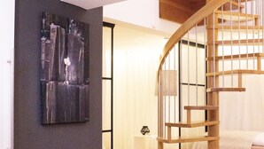 A modern interior with a wooden spiral staircase, a large abstract painting, and a minimalist design. - Best deal in town ! Como Designer Apt deluxe in the center of Munich (Munich)