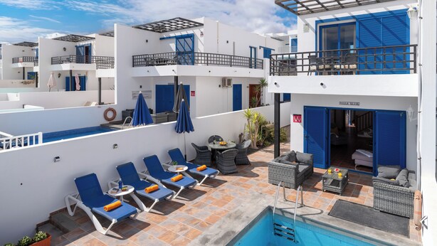 A rooftop pool area with lounge chairs, a small table, and a pool. - Air-conditioned Villa With Mountain Views, 300m From Coastal Path - Villa Elise (playa blanca)