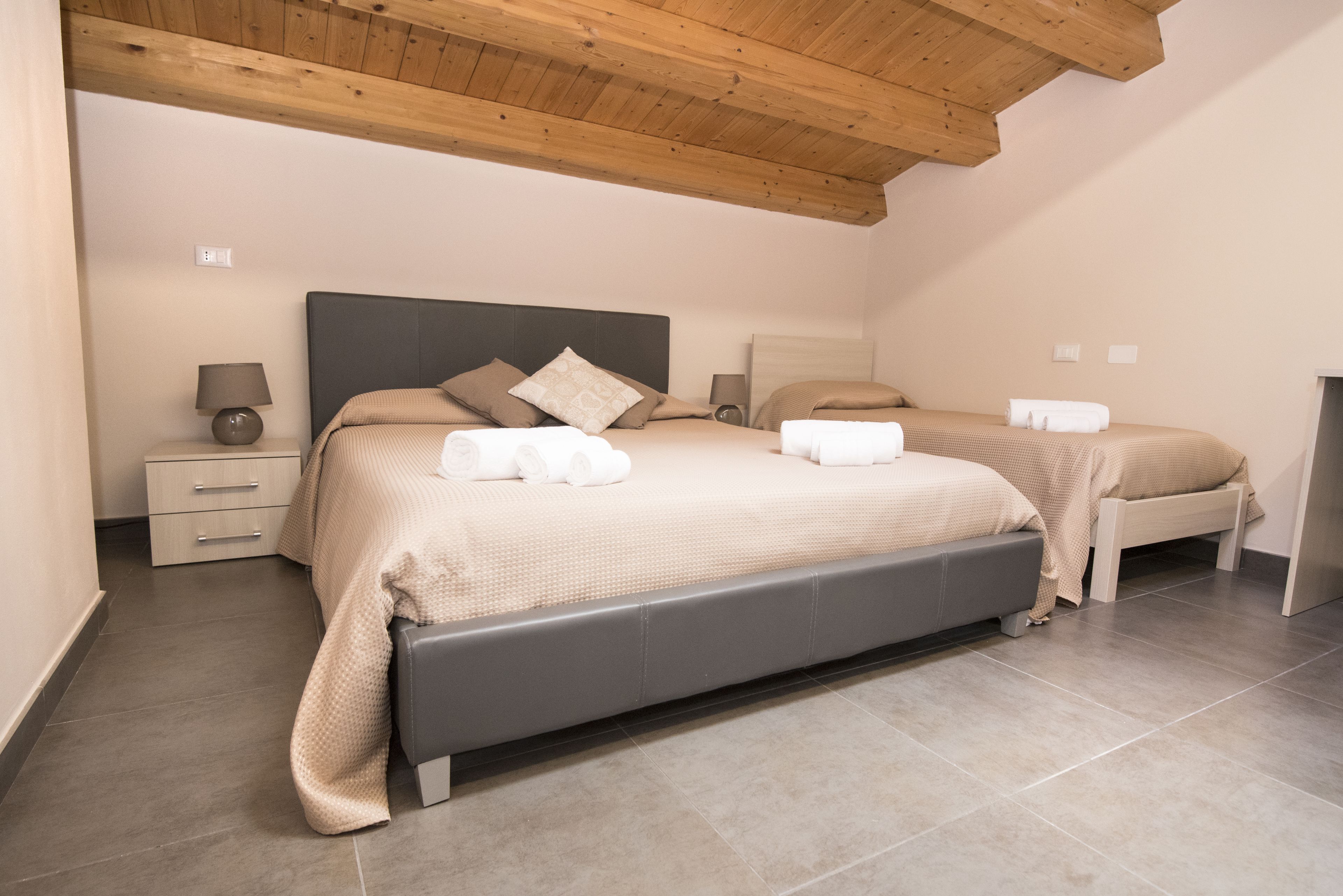 Ein Schlafzimmer mit zwei Betten, einem Nachttisch und einer Bank.