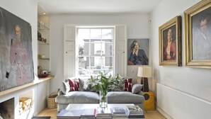 Un salon comprenant un canapé, une table basse et une fenêtre donnant sur un immeuble.