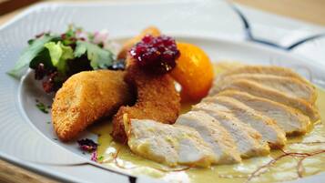 Ein Teller mit paniertem Hähnchen, Obst und einem gemischten Salat.