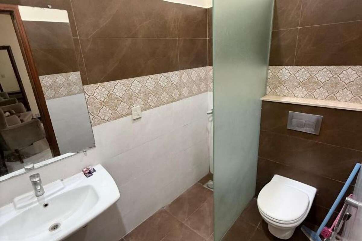 A bathroom with a sink, toilet, and a mirror.