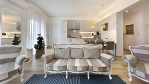 Un salon moderne avec un canapé à rayures, un coin repas et une cuisine en arrière-plan.