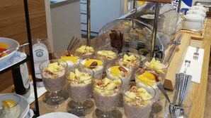 Montaje de bufé con diversos alimentos, incluyendo pasteles y una exposición de carnes.