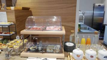 Un'area buffet con diversi cibi, tra cui carni, insalate e bevande.
