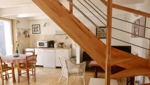 A kitchen with white cabinets, a microwave, and a dining area with a table and chairs.