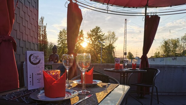 An outdoor dining area with tables set for two, featuring clear glassware and red napkins. - Minsu Hotel (Muelheim an der Ruhr)