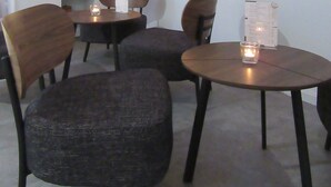 A modern living room with a flat-screen TV, a dining area with two chairs and a table, and a window with a decorative garland. - Minsu Hotel (Muelheim an der Ruhr)