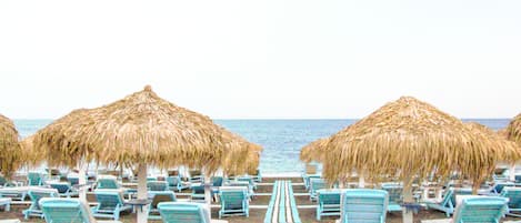 Plage privée, sable noir, chaises longues, parasols