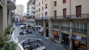 Une rue urbaine à plusieurs niveaux, dotée d’espaces de stationnement extérieurs, de boutiques et d’immeubles résidentiels.