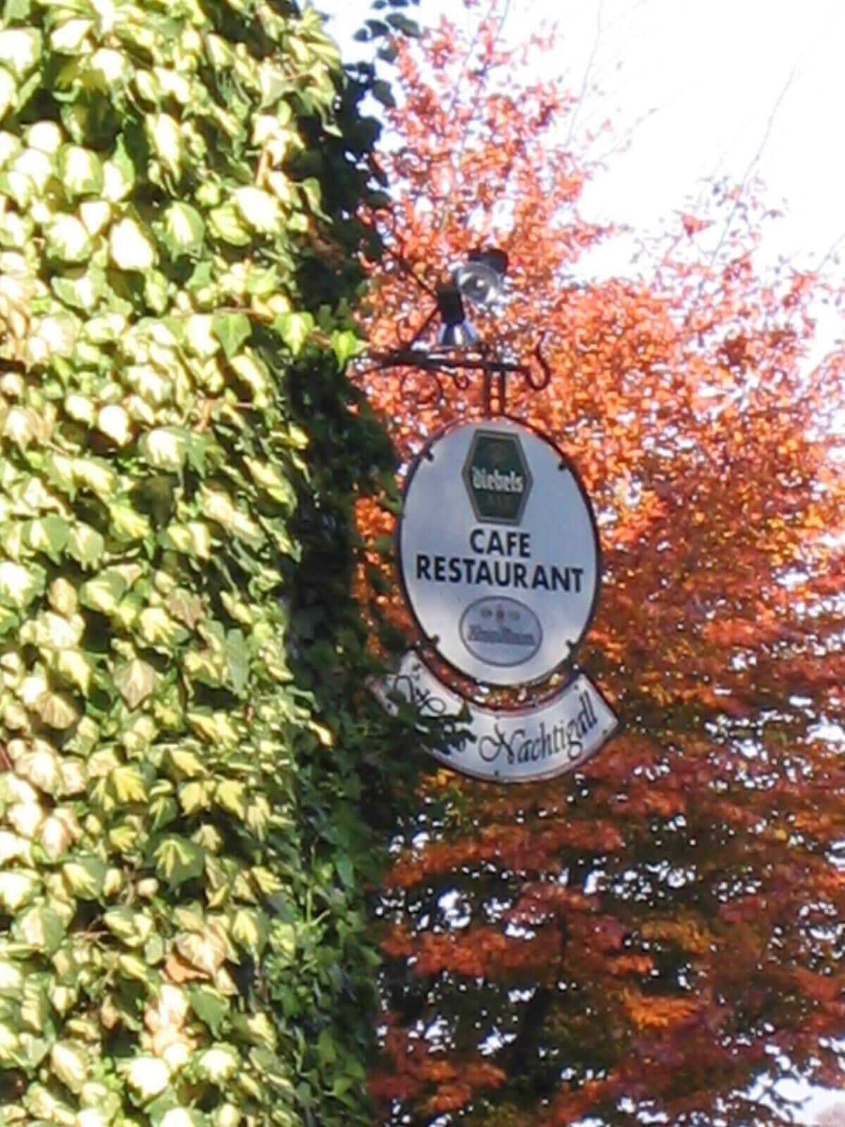 Un letrero de cafetería con el nombre 'Cafe Restaurant' y 'Nachtigal' escritos en él.