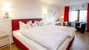Une chambre d’hôtel avec un grand lit, un bureau et une chaise.