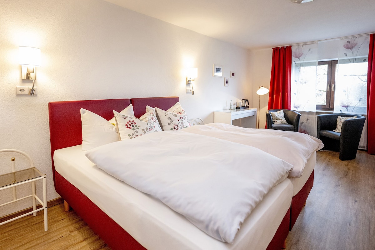 Habitació d'hotel amb un llit gran, una taula i una cadira.