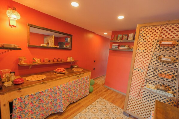 A room with a wooden counter, a mirror, shelves with books, and a patterned rug. - Frau Guler (Amasra)