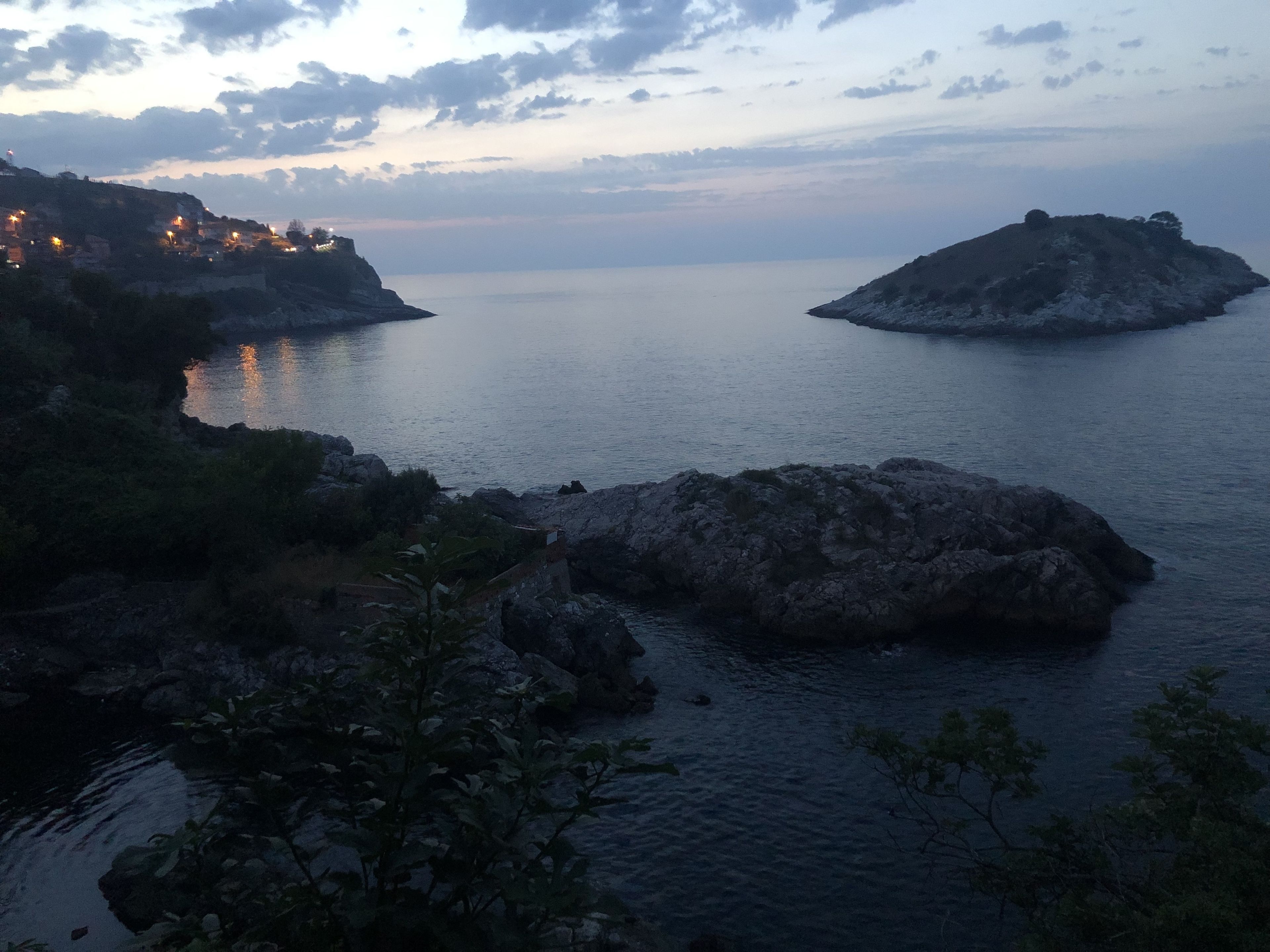 Un paysage côtier caractérisé par un terrain rocheux et une mer calme.
