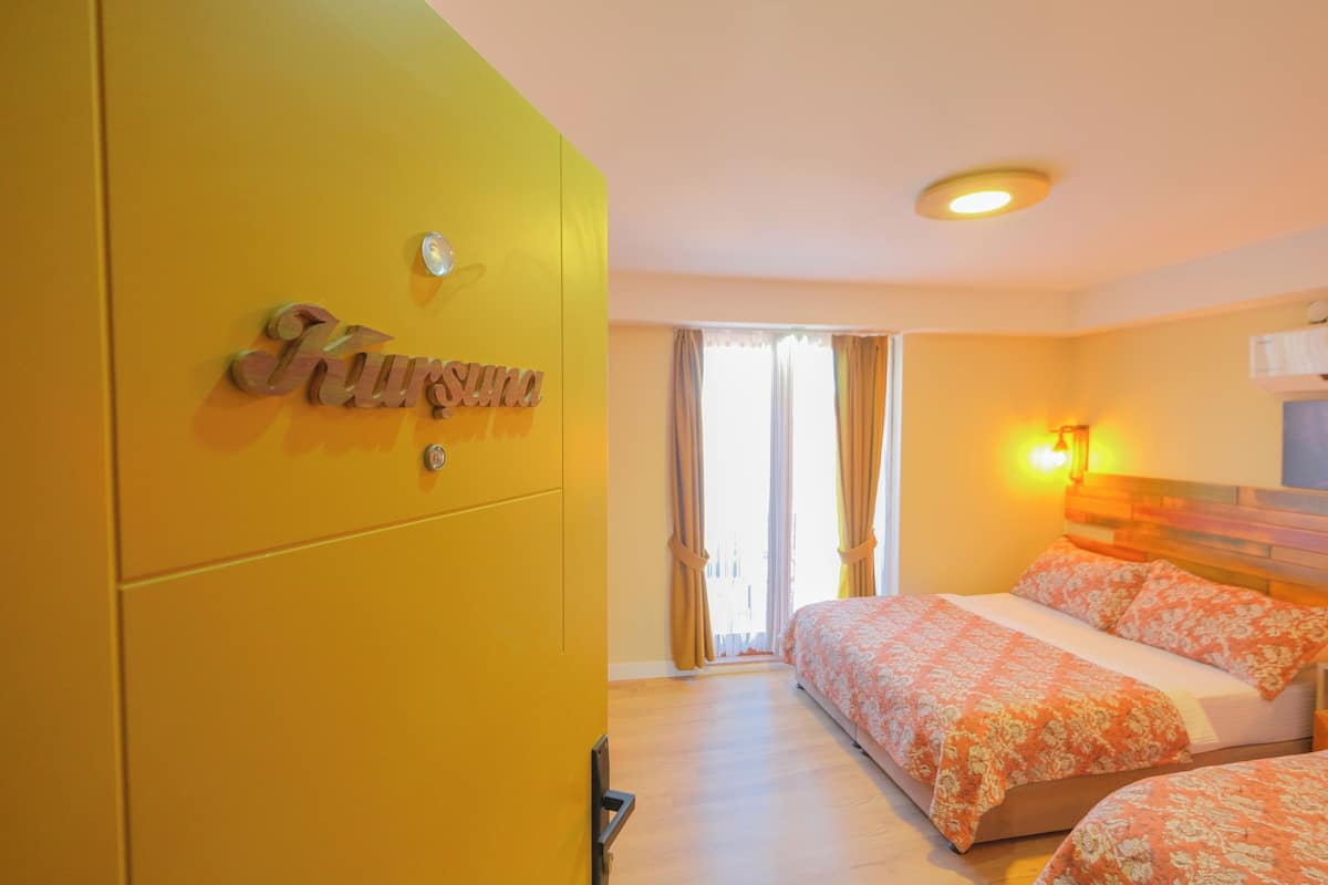A hotel room with a bed, a wardrobe, and a window with curtains.