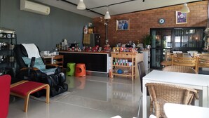 A modern interior with a seating area, a counter with various items, and a brick wall. - The Lofts Eco (Sung Noen)