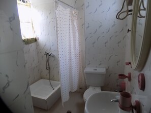 A bathroom with a bathtub, toilet, and sink.