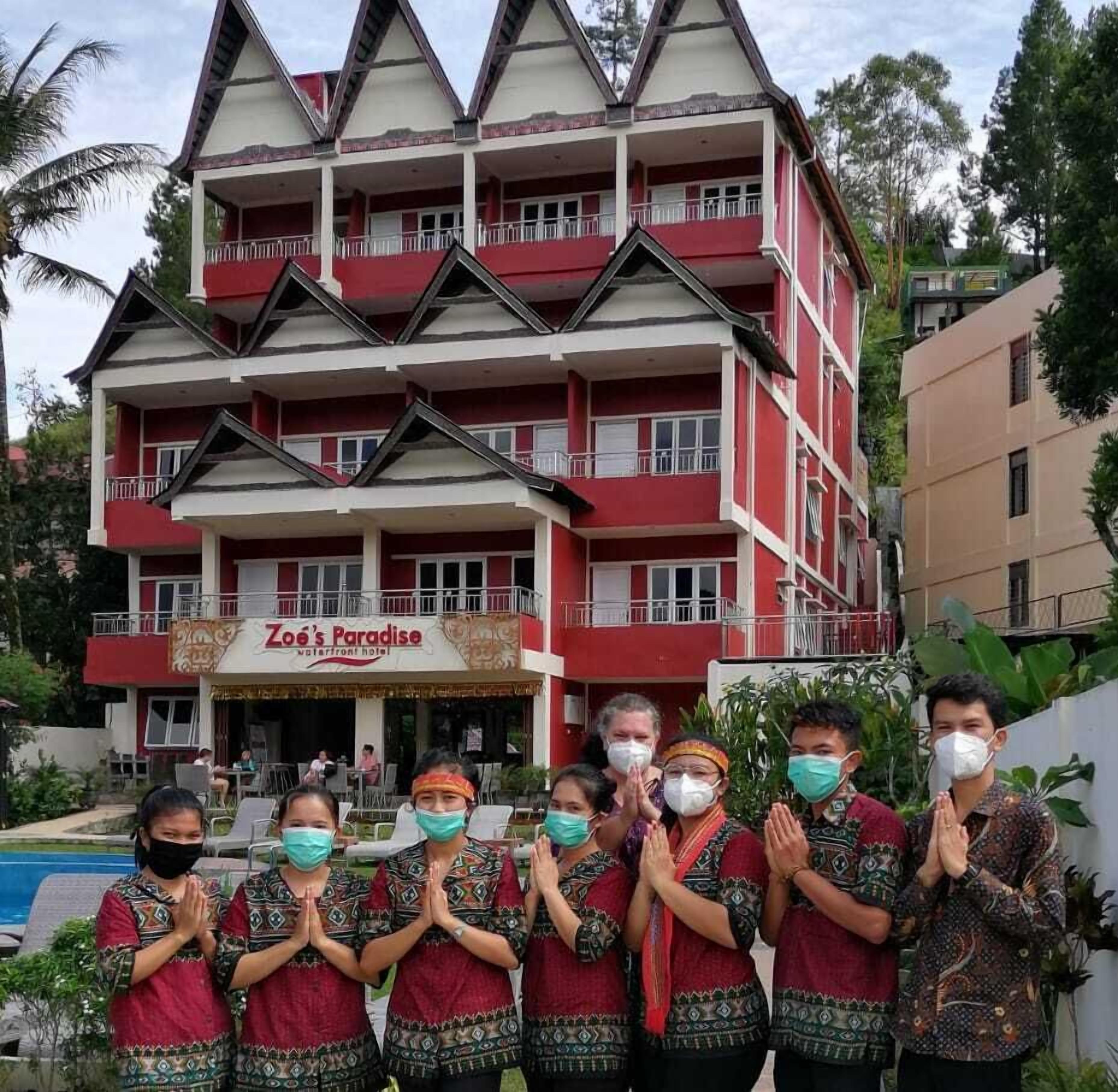 A multi-story building with a red and white facade, named "Zoe's Paradise."