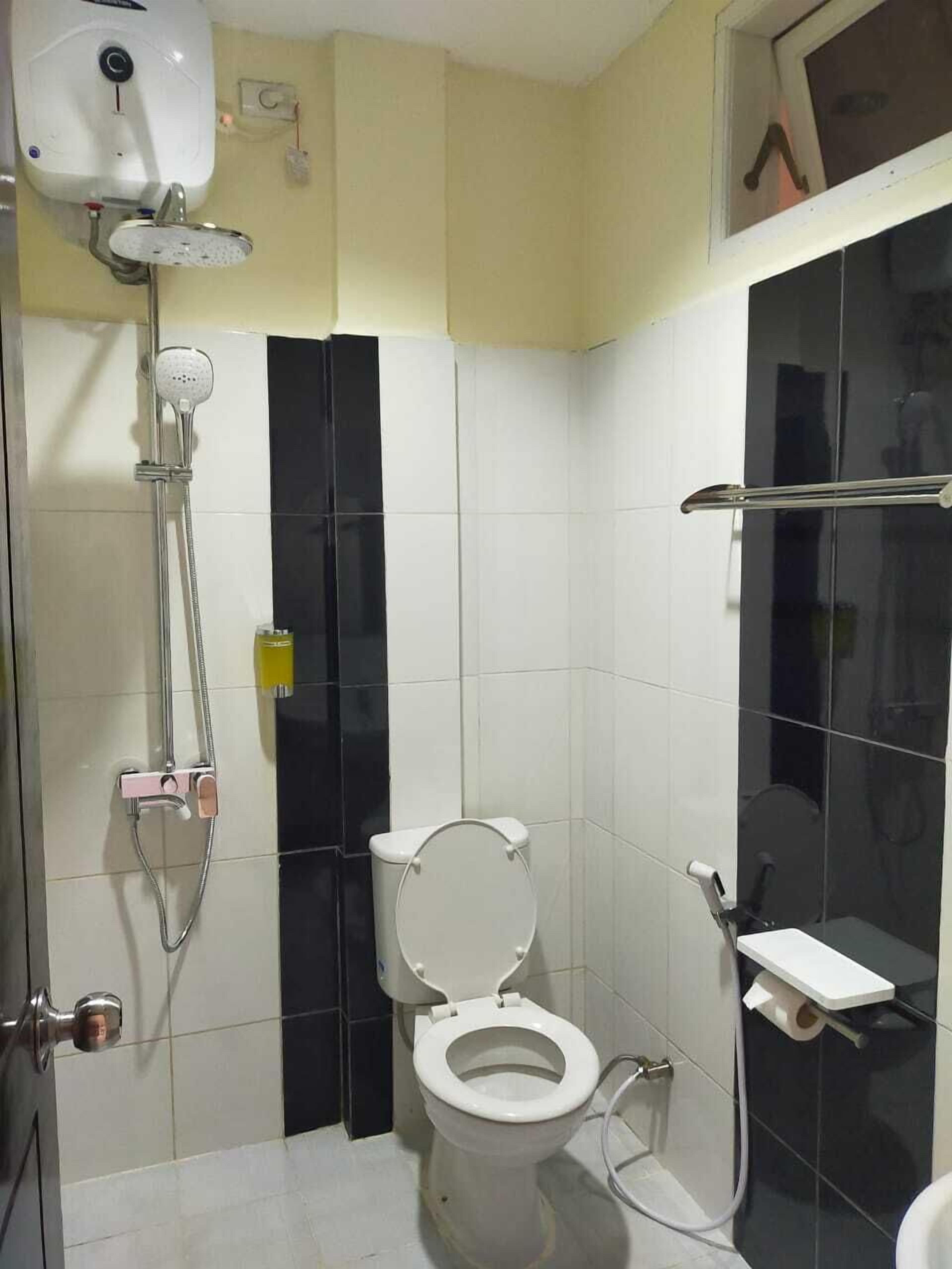 A small bathroom with a toilet, a shower, and a toilet paper holder.