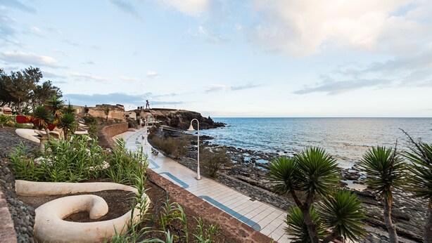 A coastal walkway with a rocky path, palm trees, and a view of the sea. - Nice frontline apartment in Playa de Arinaga (Arinaga)