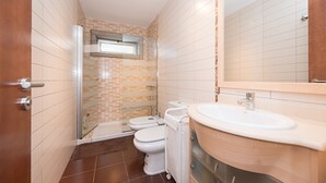 A modern bathroom with a shower, two toilets, a sink, and a mirror. - Nice frontline apartment in Playa de Arinaga (Arinaga)