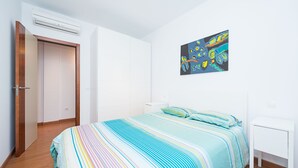 A bedroom with a bed, a nightstand, a painting, and an air conditioning unit. - Nice frontline apartment in Playa de Arinaga (Arinaga)