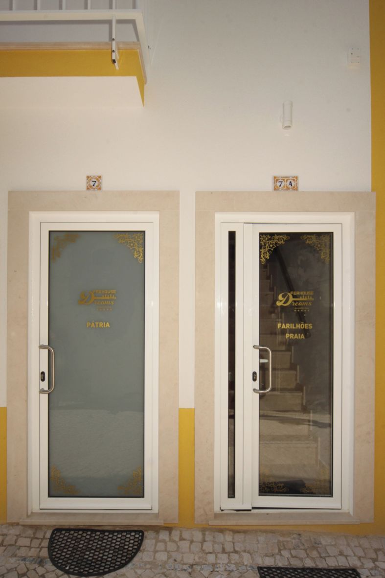 Two doors with glass panels, one labeled "PATRIA" and the other "FARILHOES PRAIA".