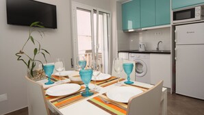 A modern kitchen with teal cabinets, a washing machine, and a microwave. - Ferhouse Dreams- Farilhões (Nazaré)