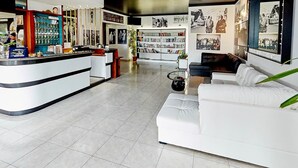Una sala de estar moderna con un sofá blanco, una mesa de centro y una estantería llena de libros.