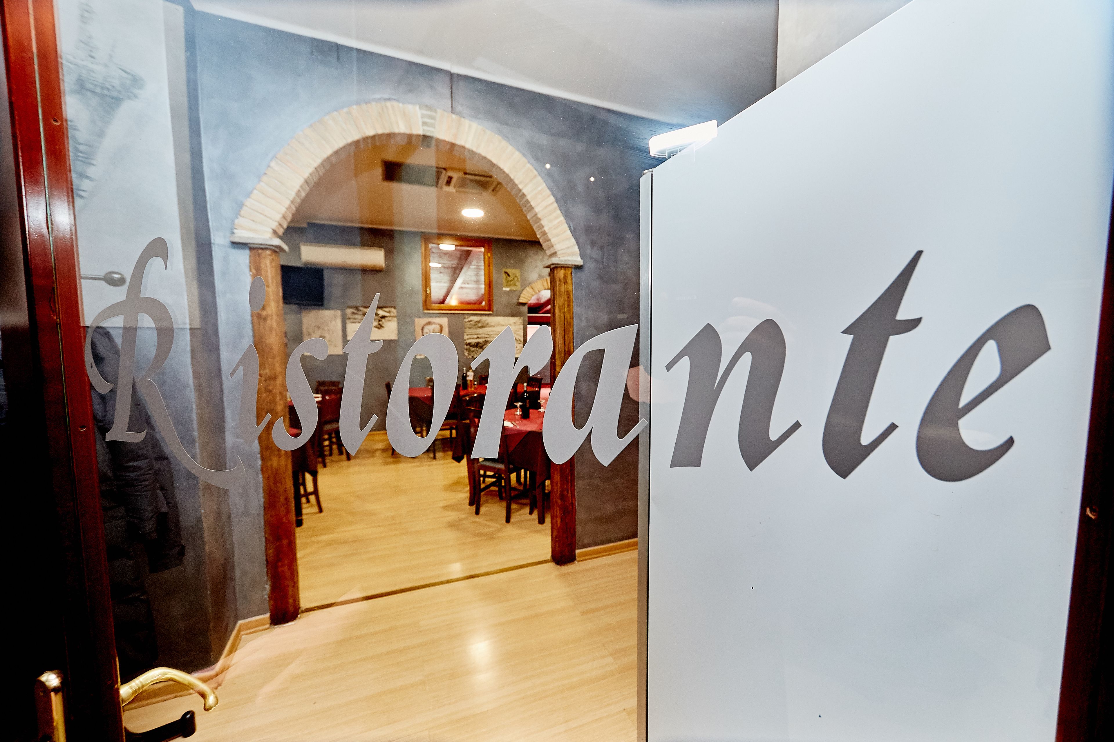 A restaurant interior with a large sign reading "Restaurante" and a wooden floor.