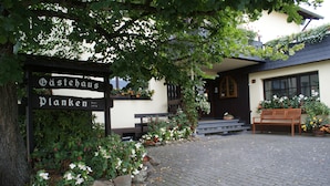 Ein traditionelles Gebäude mit einem Schild, auf dem „Gästehaus Planken“ steht.